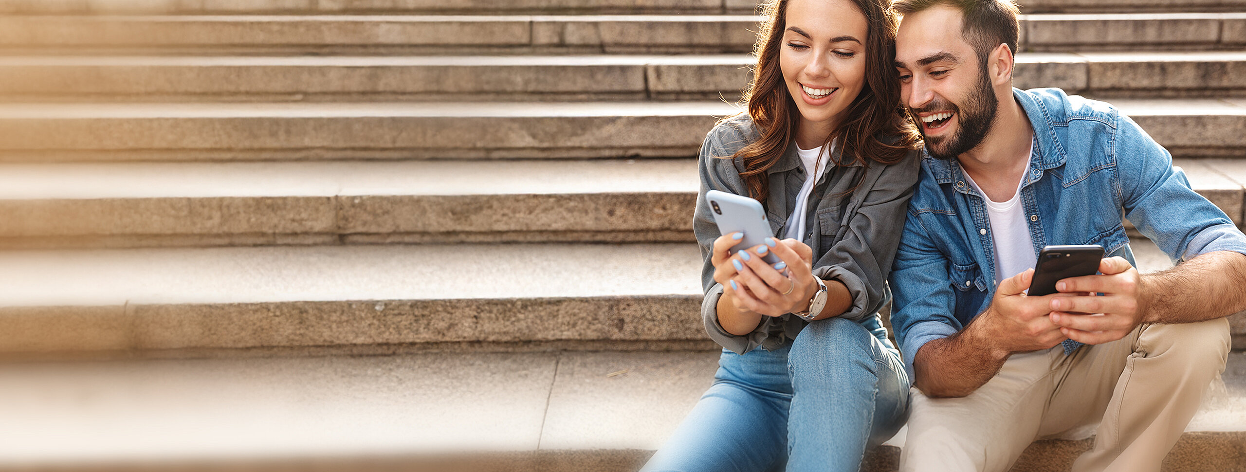 Pärchen mit Smartphones auf einer Treppe